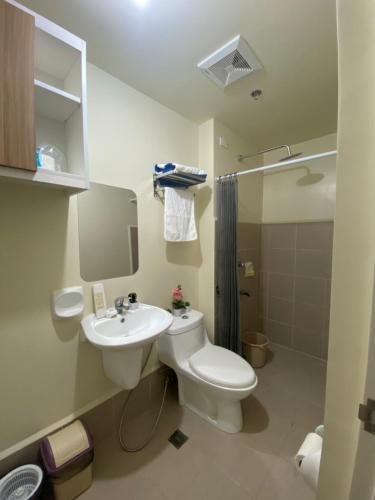 a bathroom with a toilet and a sink and a shower at Cozy studio unit 10mins from Airport 20mins from US Embassy across SM Sucat in Manila