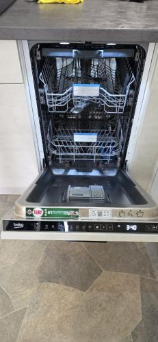 an open dishwasher with its door open on a floor at Heïdi 7 in Middelkerke