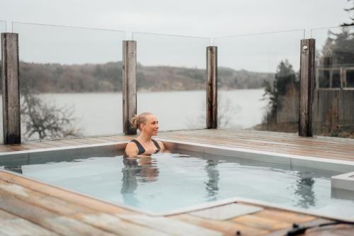 a woman in a swimming pool next to a body of water at Vann Spa Hotell & Konferens in Brastad