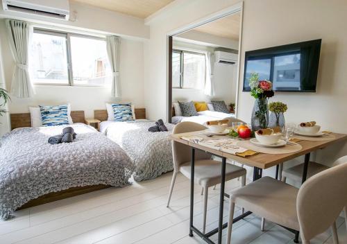 a bedroom with a bed and a dining room with a table at Asakusabashi Condominium Hotel in Tokyo