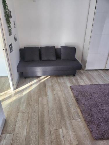 a black couch sitting in a room next to a door at La villa de Fleury in Fleury