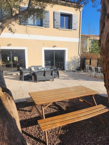 a wooden picnic table in front of a building at La villa de Fleury in Fleury