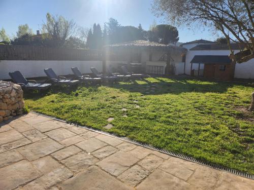 a yard with lounge chairs and a fence at La villa de Fleury in Fleury