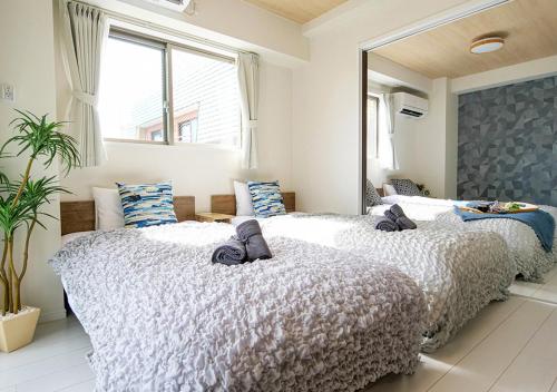 two beds in a bedroom with a large mirror at Asakusabashi Condominium Hotel in Tokyo