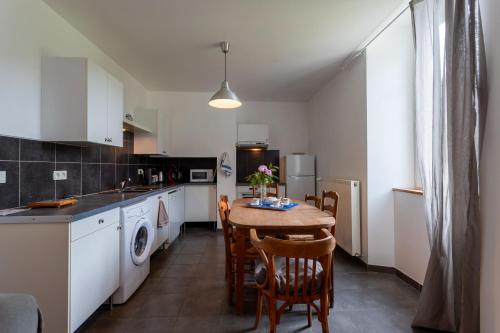 une cuisine avec une table et des chaises dans une pièce dans l'établissement Gite Tété près de Lourdes, à Artigues