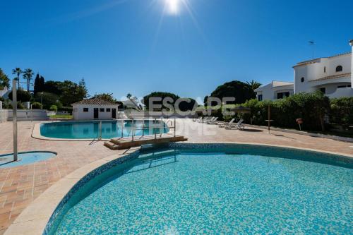 a swimming pool in front of a building at Villa Estrela do Mar in Porches