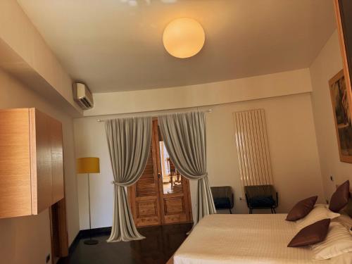 een slaapkamer met een bed en een raam met gordijnen bij Luxury Villa with Pool and Garden in Ricadi