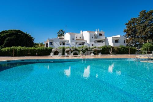 a large swimming pool in front of a white building at Villa Estrela do Mar in Porches