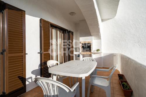 a dining room with a table and white chairs at Villa Estrela do Mar in Porches
