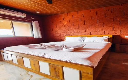 un letto in una stanza con tre ciotole sopra di Red Brick Resort a Mahabaleshwar