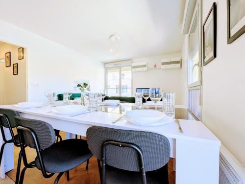 une salle à manger avec une grande table blanche et des chaises dans l'établissement Chic and comfortable apart with Parking and Terrace, à Asnières-sur-Seine