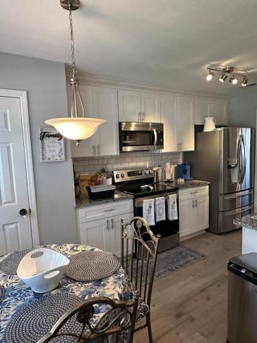 a kitchen with white cabinets and a table with a tableablish at Cozy Stay in Hephzibah in Hephzibah