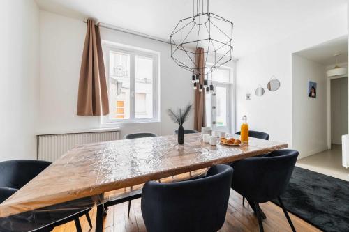 une salle à manger avec une grande table et des chaises en bois dans l'établissement Appartement Confortable Sacre Coeur - Paris 18 - 6P, à Paris