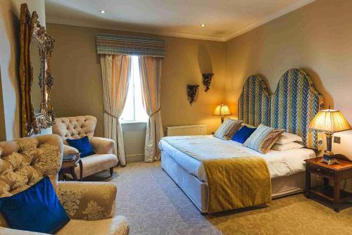 a bedroom with a large bed and a chair at Ye Olde Bell Hotel & Spa in Retford