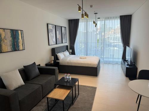 a living room with a bed and a couch and a tv at Disalvo Smart and Luxury Studio in Dubai