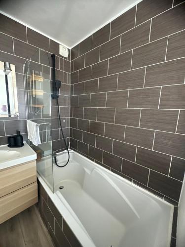 une salle de bain avec une baignoire et un lavabo dans l'établissement Appartement cosy Saint Denis, à Saint-Denis