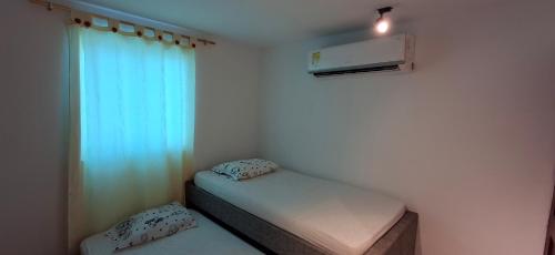 a small room with a bed and a window at Apartamento la playa in Barranquilla