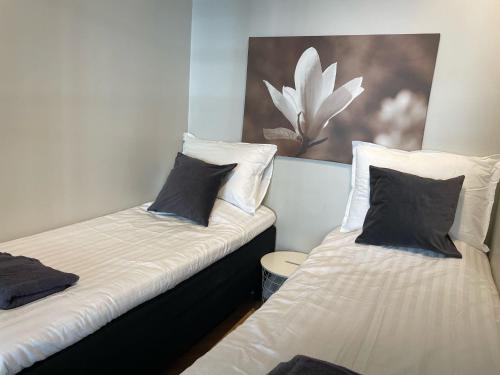 2 letti singoli in una camera con un dipinto sul muro di Luxury 2BDR Apartment in Center with Free Parking a Helsinki
