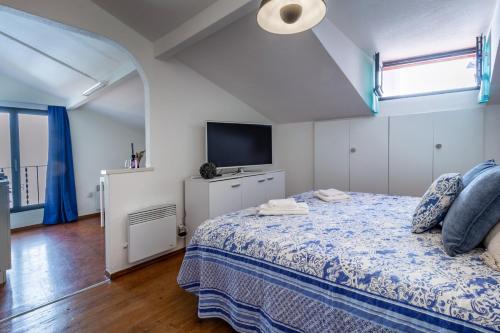 a bedroom with a bed and a flat screen tv at Essenzial Piazza Grande Locarno in Locarno