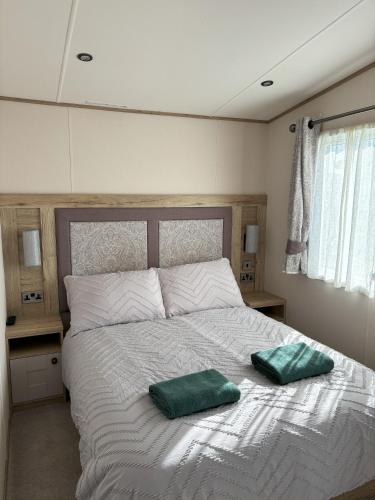 a bedroom with a bed with two green pillows on it at 256 North Park in North Seaton