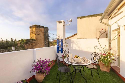 eine Terrasse mit Tisch und Stühlen auf einem Balkon in der Unterkunft Casa 3 plantas con patio y Solárium privados in Córdoba