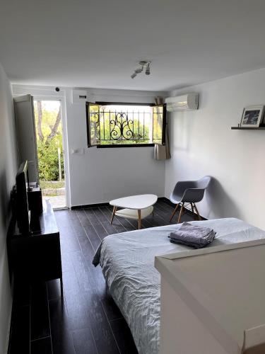 une chambre avec un lit, une table et une fenêtre dans l'établissement Charmant studio à Nice avec accès piscine, à Nice
