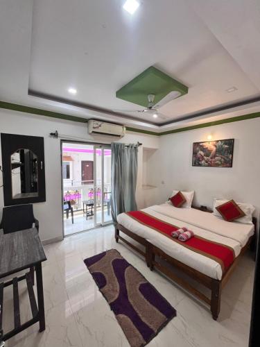 a bedroom with a bed and a desk in a room at Hotel Queen Queen Sea in Calangute