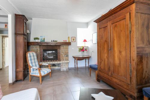 - un salon avec une cheminée et une armoire en bois dans l'établissement La maison de pêcheur Chez Alice, à Pontrieux