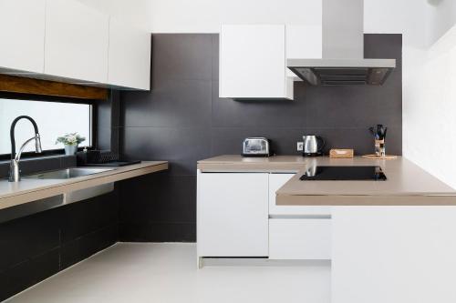 a kitchen with white cabinets and a sink at Kamezí Boutique Hotel Villas in Playa Blanca