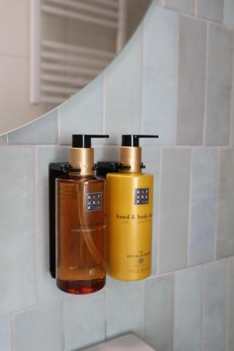 two bottles ofodorizers sitting on a shelf in a bathroom at POLANKI AQUA Apartamenty PREMIUM - w cenie nielimitowany dostęp do strefy Aqua in Kołobrzeg
