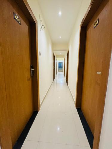 a corridor of an office building with wooden doors at Hotel Cliff Garden in Mumbai