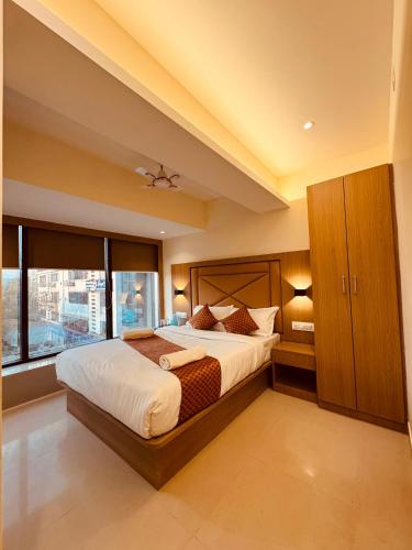 a bedroom with a large bed and a large window at Hotel Cliff Garden in Mumbai