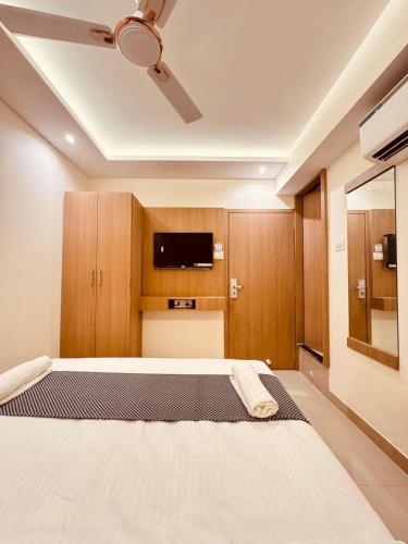 a bedroom with a bed and a flat screen tv at Hotel Cliff Garden in Mumbai