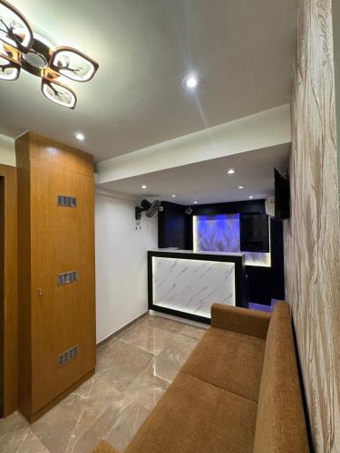 a living room with a couch and a large screen tv at Hotel Cliff Garden in Mumbai