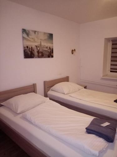 two beds in a room with a picture on the wall at Hotel Olimpik Park in Słubice