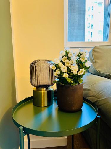 a table with a lamp and a vase of flowers on it at MilanLife Apartments - DTown Charme in Milan