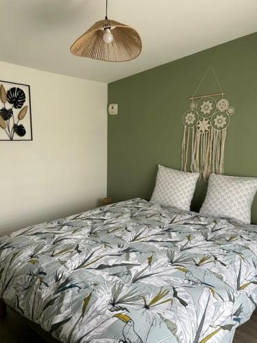 a bedroom with a bed with a floral comforter at Appartement 29D à Mailly-le-Camp in Mailly-le-Camp