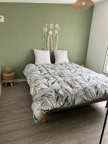 a bedroom with a large bed with a comforter at Appartement 29D à Mailly-le-Camp in Mailly-le-Camp