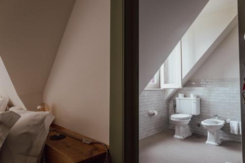 a attic bathroom with a toilet and a sink at Chalet Ficalho in Cascais