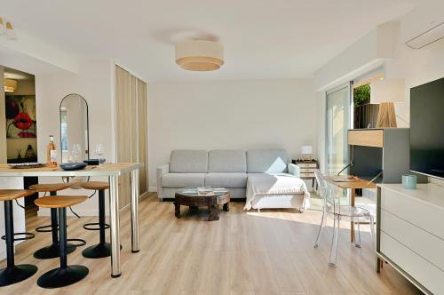 a living room with a couch and a table at Renovated 2-room apartment near sea & shops in Théoule-sur-Mer