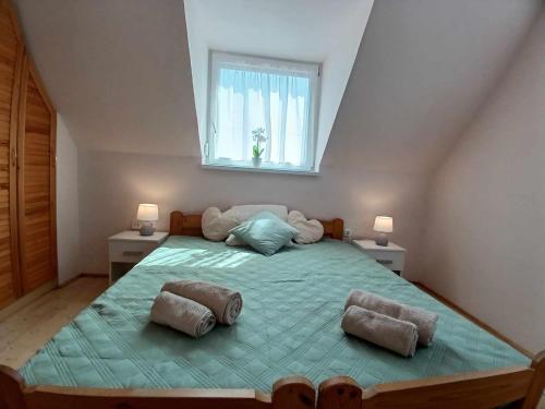 a bedroom with a large bed with two pillows on it at Lent a Parton Apartmanház in Balatonudvari