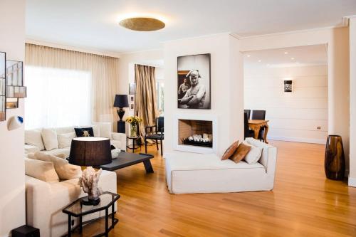 ein Wohnzimmer mit weißen Möbeln und einem Kamin in der Unterkunft South Blue Tranquil Villa in Athen