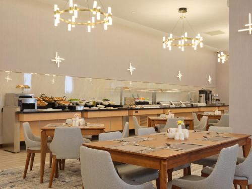 a dining room with tables and chairs and a kitchen at The Central Point Hotel Baku in Baku