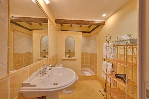 une salle de bain avec un lavabo et un miroir dans l'établissement La Bastide des Princes, Indoor and Outdoor Pools, à Caderousse