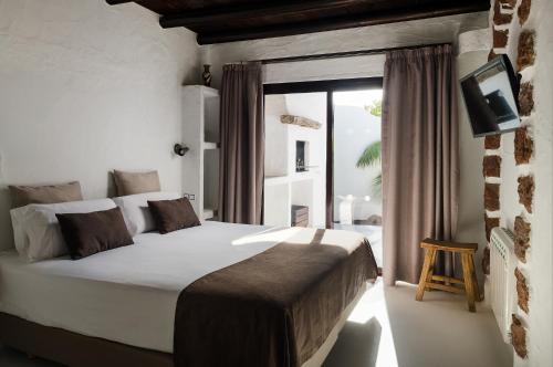 a bedroom with a large white bed and a window at Kamezí Boutique Hotel Villas in Playa Blanca