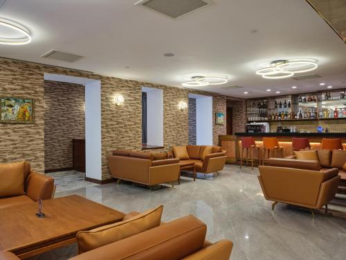a waiting room with couches and a bar at The Central Point Hotel Baku in Baku