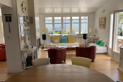 un salon avec un canapé, une table et des chaises dans l'établissement Charming House with Pool, à Saint-Martin-de-Ré