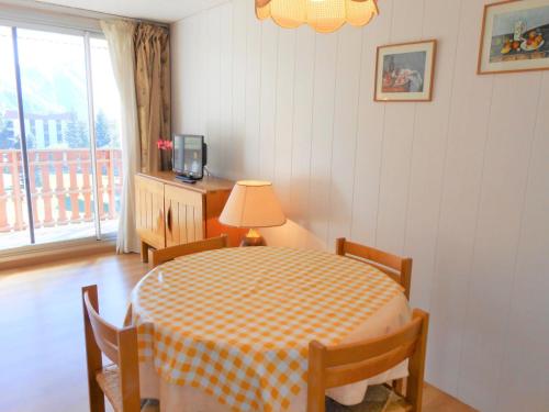 une salle à manger avec une table et des chaises et une fenêtre dans l'établissement Studio cosy, au pied des pistes avec balcon, parking et casier à ski - FR-1-516-37, à Les Deux Alpes
