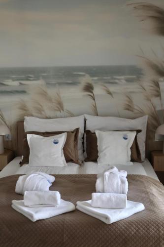 a bed with towels sitting on top of it at POLANKI AQUA Apartamenty PREMIUM - w cenie nielimitowany dostęp do strefy Aqua in Kołobrzeg