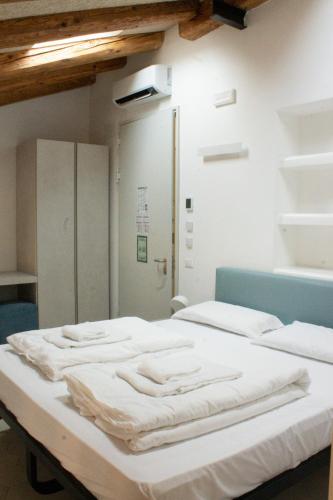 a hospital room with a bed with white sheets at Casali Hostel in Trieste